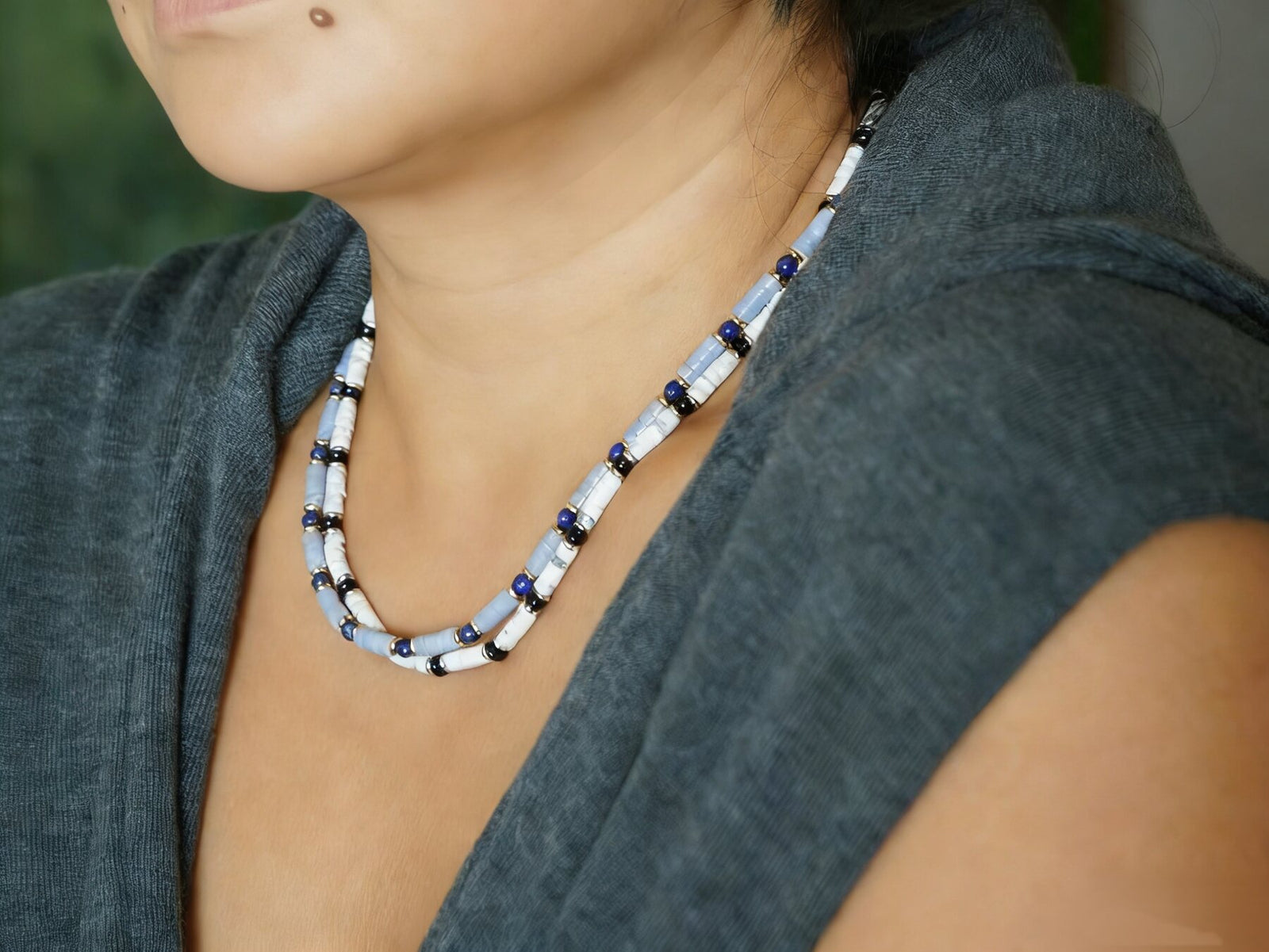 Layered blue and white KINGRAX natural stone necklaces worn on the body